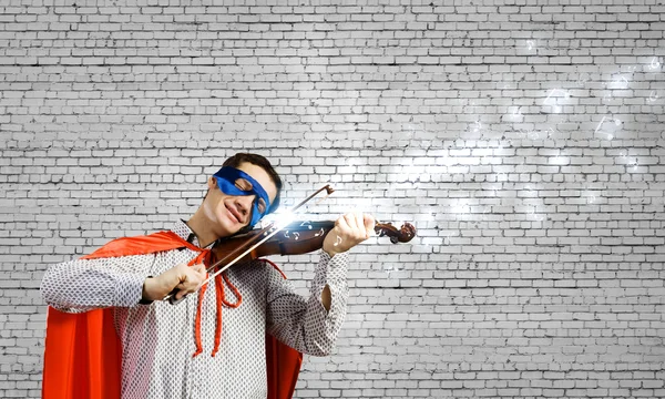 Супермен играет на скрипке — стоковое фото