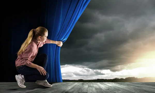 Mulher olhando para fora da cortina — Fotografia de Stock