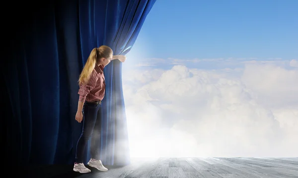 Woman looking out from curtain — Stock Photo, Image