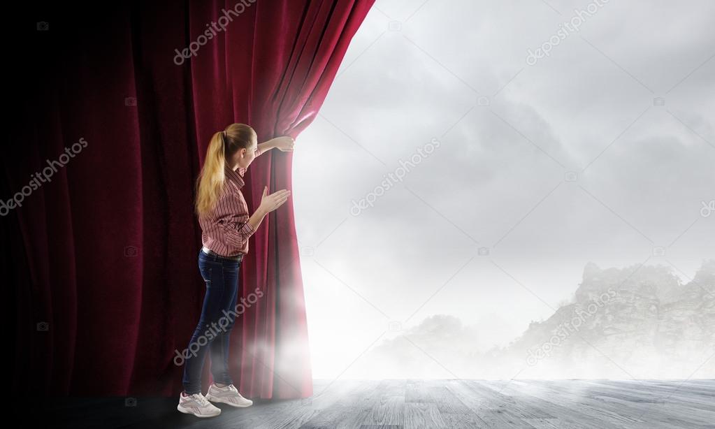 Woman looking out from curtain