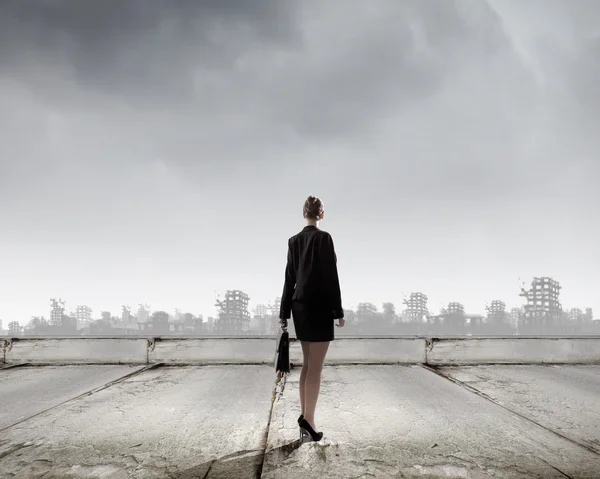 Businesswoman looking at ruins of city — Stock Photo, Image