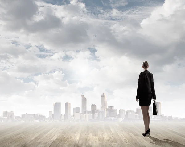 Businesswoman looking at ruins of city — Stock Photo, Image