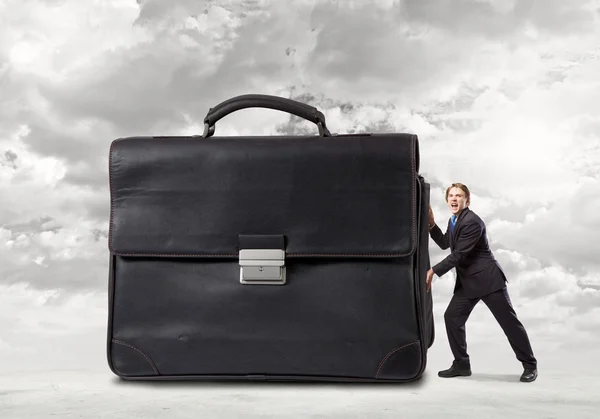 Homme d'affaires poussant grande valise lourde — Photo