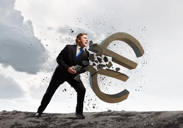 Businessman breaking stone euro sign — Stock Photo, Image