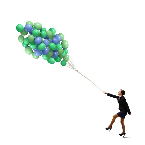 Businesswoman walking with bunch of colorful balloons — Stock Photo, Image