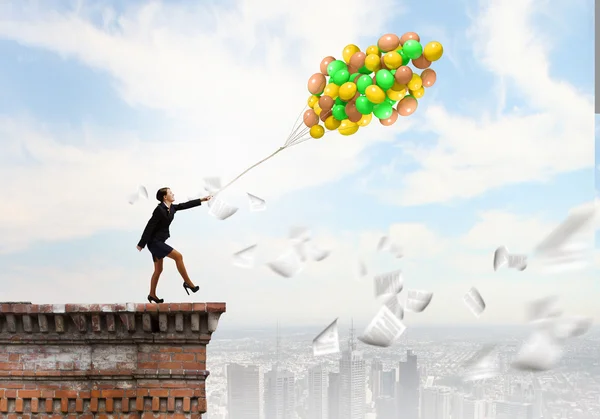 Mujer de negocios caminando con un montón de globos de colores —  Fotos de Stock