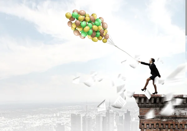 Empresária andando com um monte de balões coloridos — Fotografia de Stock