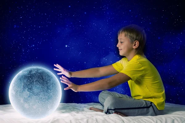 Cute boy sitting in bed and dreaming — Stock Photo, Image