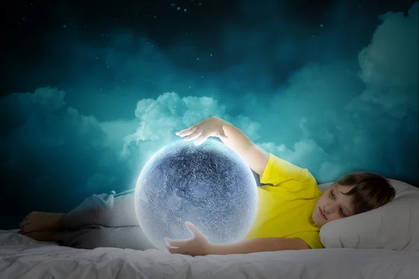 Cute boy lying in bed and dreaming — Stock Photo, Image