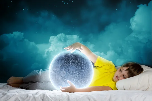 Cute boy lying in bed and dreaming — Stock Photo, Image