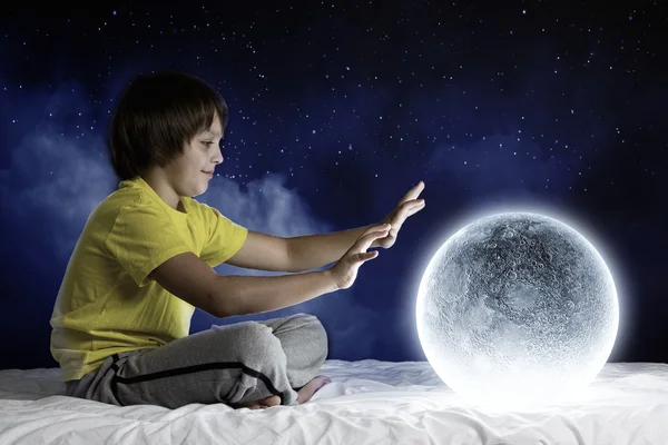 Cute boy sitting in bed and dreaming — Stock Photo, Image