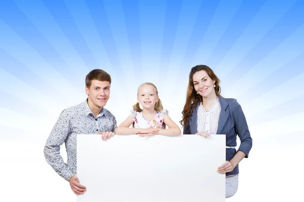 Felice famiglia in possesso di banner bianco — Foto Stock