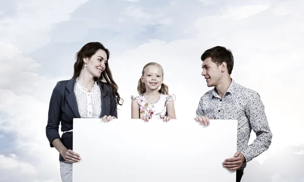 Lycklig familj håller vit blank banner — Stockfoto