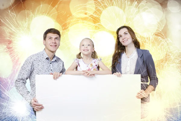 Happy family holding white blank banner — Stock Photo, Image