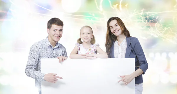 Lycklig familj håller vit blank banner — Stockfoto