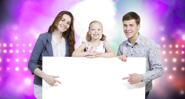 Família feliz segurando banner branco em branco — Fotografia de Stock