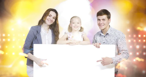 Família feliz segurando banner branco em branco — Fotografia de Stock