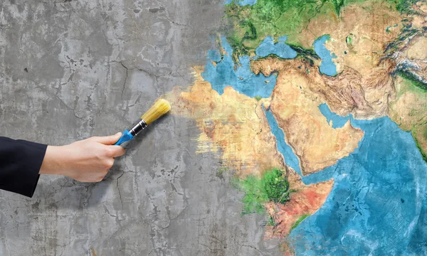 Business person hand painting Earth planet