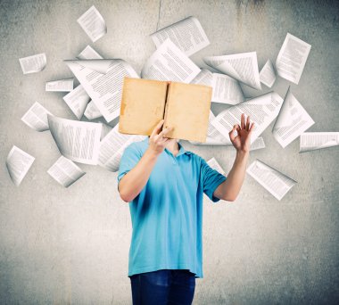 Adam açık bir kitap tutuyor.