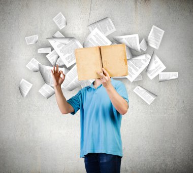 Adam açık bir kitap tutuyor.