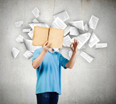 Adam açık bir kitap tutuyor.