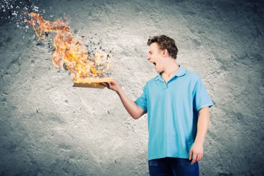 Adam açık bir kitap tutuyor.