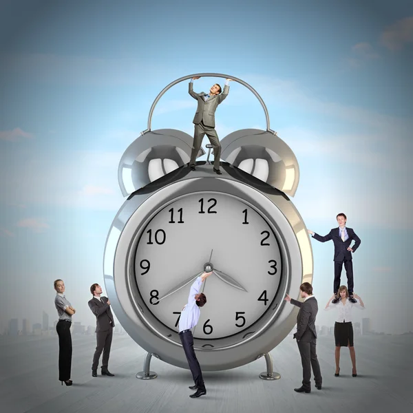 Clock and many businesspeople around — Stock Photo, Image