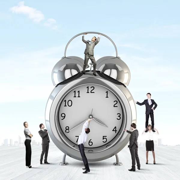 Clock and many businesspeople around — Stock Photo, Image