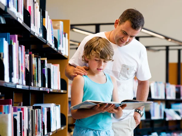 Chlapce a jeho otce v knihovně — Stock fotografie