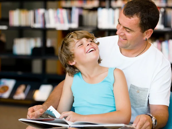 Far med sønn i biblioteket. – stockfoto