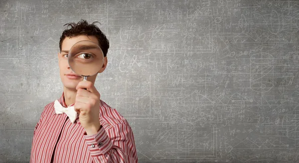 Guy looking in magnifying glass — Stock Photo, Image