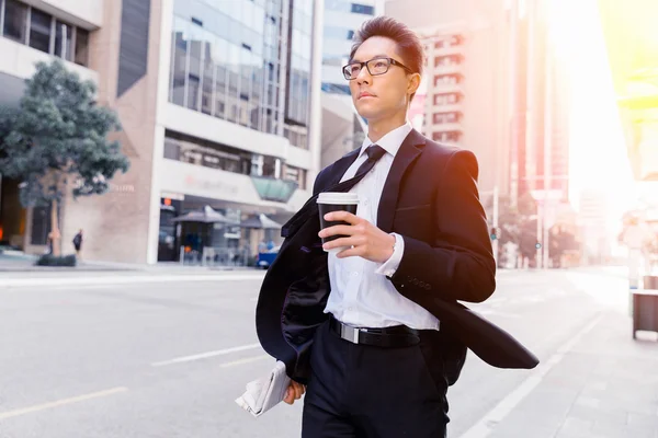 Empresario con café en una ciudad — Foto de Stock