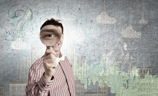 Guy looking in magnifying glass — Stock Photo, Image