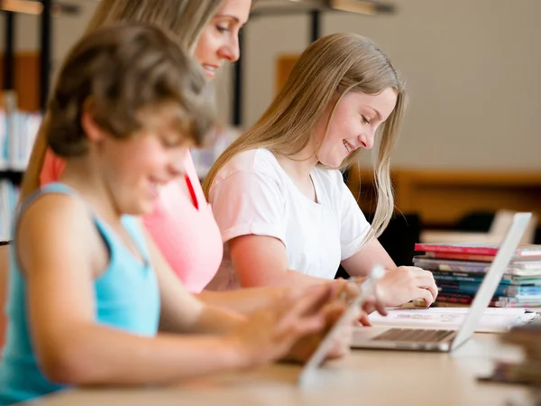 Pojke i biblioteket med dator — Stockfoto