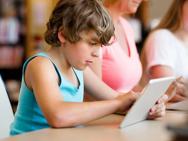 Boy in library with computer — Stock Photo, Image