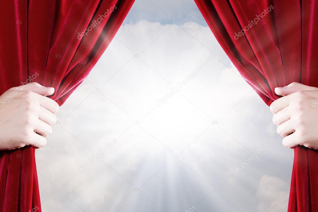 Close up of hand opening red curtain