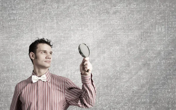 Guy looking in magnifying glass — Stock Photo, Image