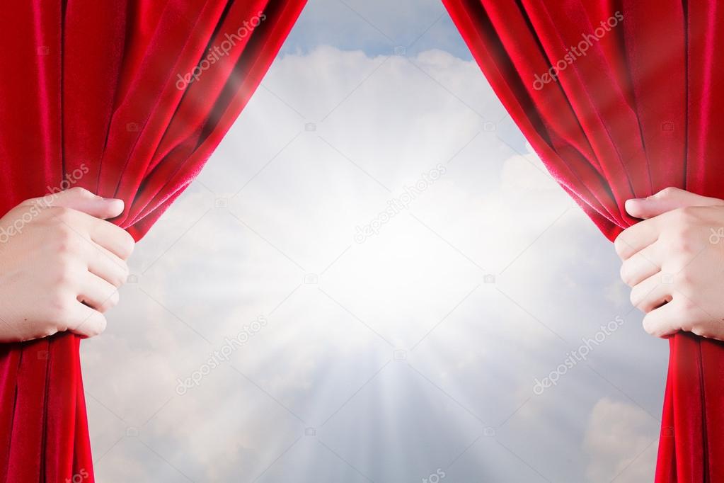 Close up of hand opening red curtain
