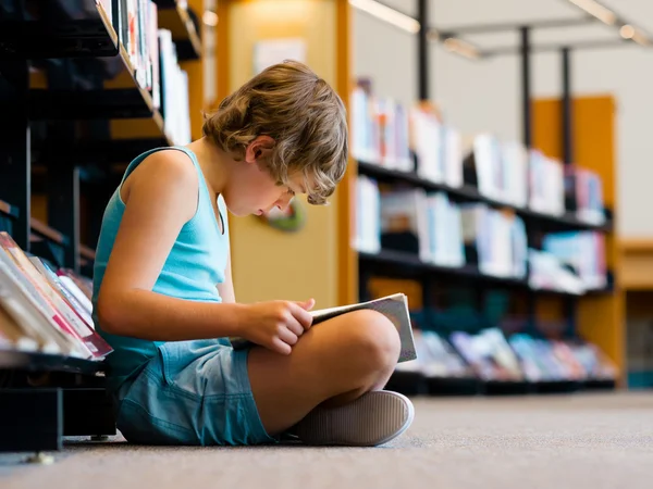 Junge in der Bibliothek — Stockfoto