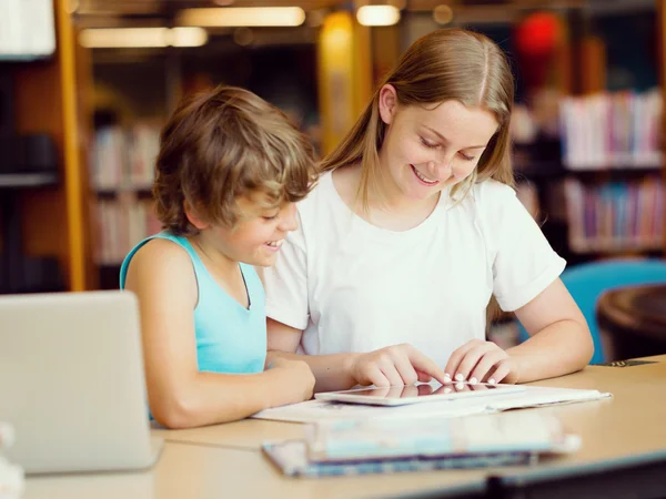 Tiener meisje en haar broer met boeken — Stockfoto