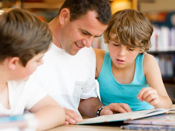 Vader met zonen in bibliotheek — Stockfoto