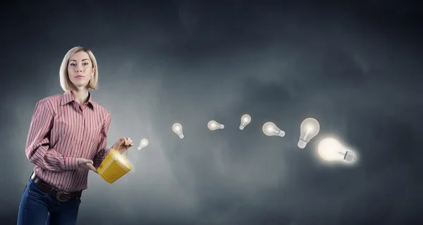 Girl splashing light bulb from bucket — Stock fotografie