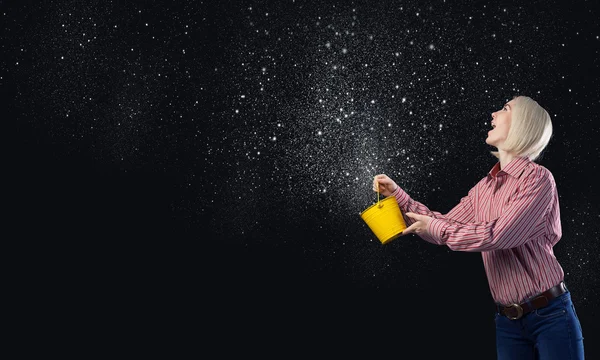 Woman splashing stars from bucket — Zdjęcie stockowe