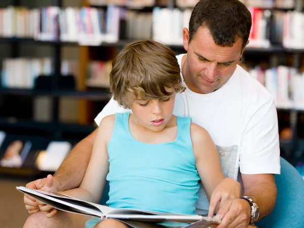 Vader en zoon in bibliotheek — Stockfoto