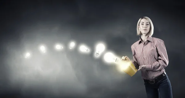 Girl splashing light bulb from bucket — Stockfoto