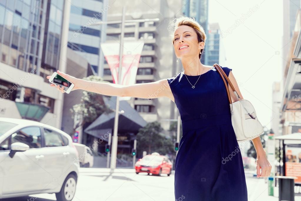 Waving for a taxi in city