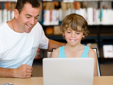 Küçük bir çocuk ve babası ile laptop