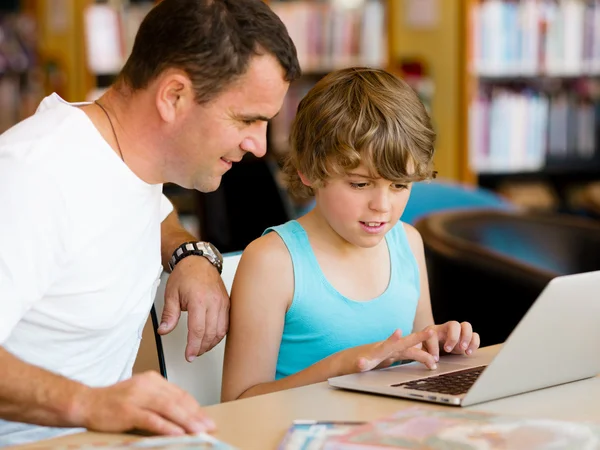 Menino e seu pai com laptop — Fotografia de Stock