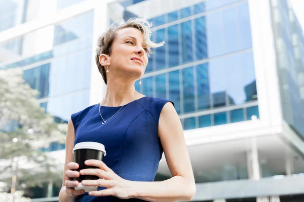 Businesswoman with coffee in a city — Stock Photo, Image