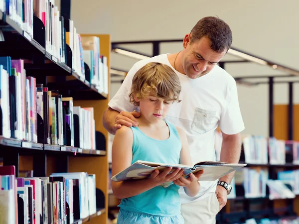 Jongen en zijn vader in bibliotheek — Stockfoto